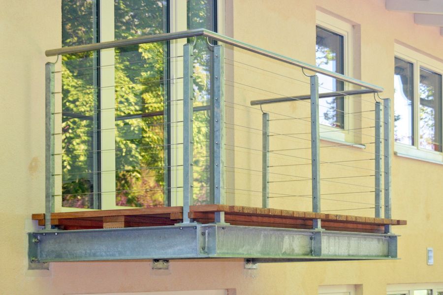 Freitragender Stahlbalkon mit Holzbelag und Gelaender mit Drahtseilfuellung