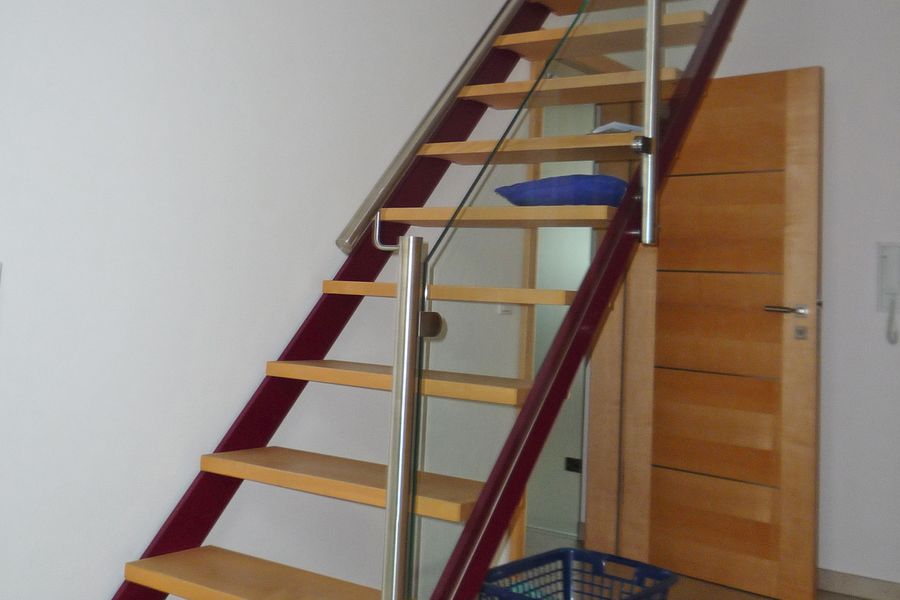 Stahltreppe ins Dachgeschoss mit Holzstufen und Edelstahl Glas Gelaender